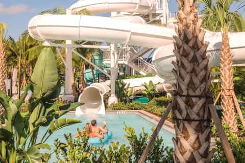 Water slide complex with palm trees and turquoise pool at all-inclusive resort