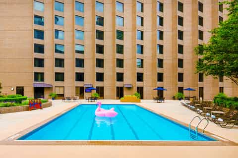 Indoor swimming pool at brick hotel with lounge chairs and blue umbrellas