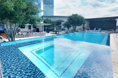 Modern resort pool with multiple lap lanes and downtown skyline in background