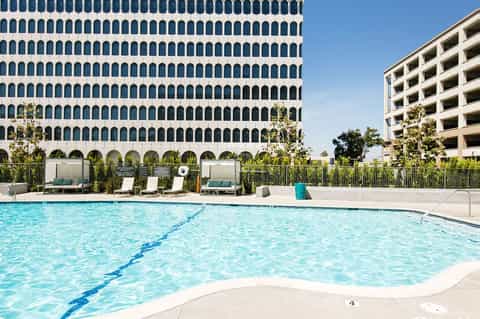 Resort lap pool with lane dividers in front of modern building with geometric window pattern