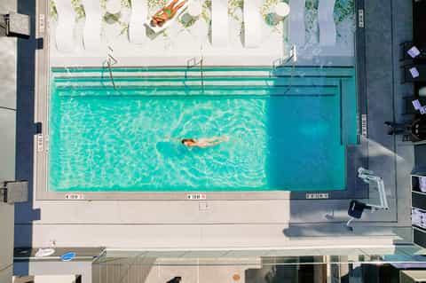Overhead view of swimmer doing laps in turquoise lap pool with lane dividers