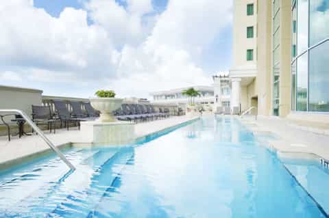 Rooftop indoor swimming pool with lane markings overlooking city buildings