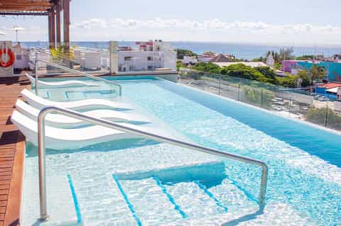 Olympic-size swimming pool with lane markers and ocean view from rooftop deck