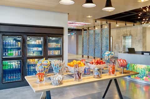 Modern hotel market with refrigerated beverage cases, snacks, and fresh fruit display