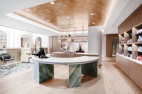 Luxurious spa reception desk with curved design, marble accents, and contemporary decor