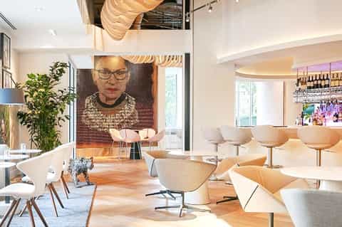Modern hotel lobby with contemporary furniture, wooden accents, and a portrait artwork