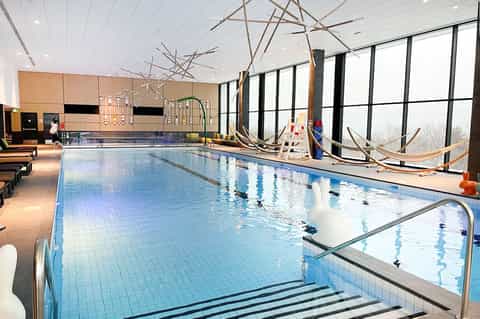 Indoor swimming pool with lane markings and large windows