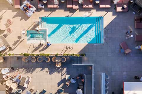 Aerial view of rectangular lap pool with turquoise water, surrounded by lounge chairs and patio
