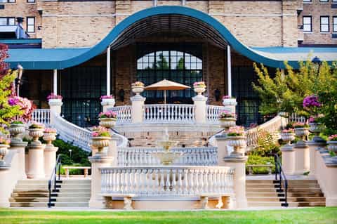 Elegant white balustrade terrace with blue arched entrance and flowering planters