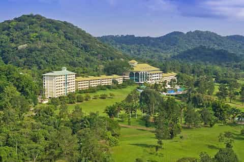 Luxury resort nestled in lush green mountains with modern architecture and pool facilities