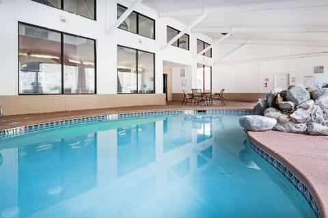 Indoor lap pool with lane markers and pink seating area with decorative rocks
