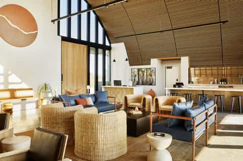 Modern resort lobby with wicker seating, wooden beams, and contemporary design