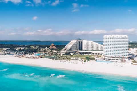 Beachfront all-inclusive resort with pyramid-shaped buildings, white sand beach, and turquoise ocean