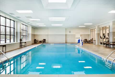 Indoor lap pool with lane markings, natural lighting, and modern facility architecture