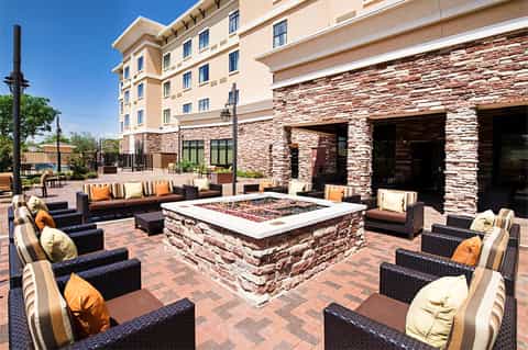 Resort patio with fire pit, wicker furniture, and stone accents