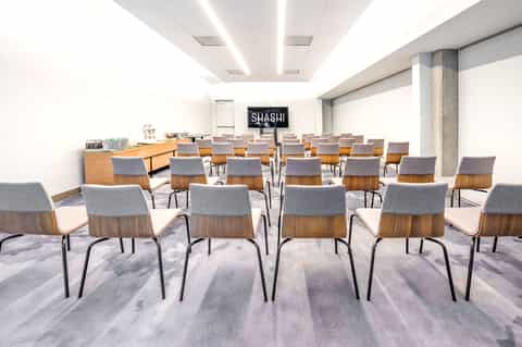 Modern conference room with wooden chairs and glass refreshment station