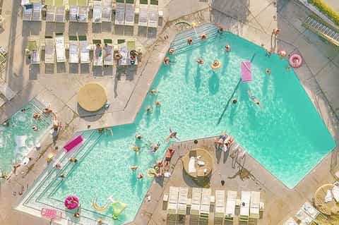 Overhead view of resort pool with colorful floats and lounge chairs on surrounding deck