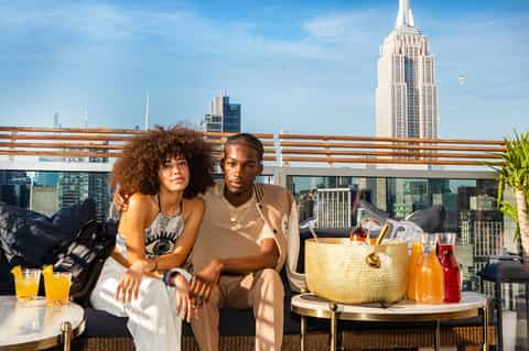 Couple on rooftop terrace with Empire State Building and NYC skyline views