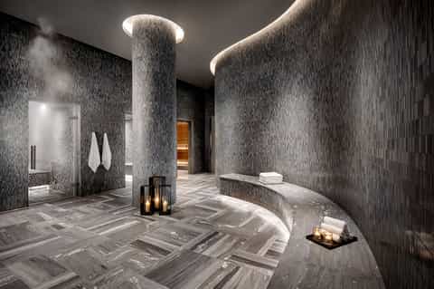 Modern spa area with rainfall columns, mosaic tile walls, and ambient lighting
