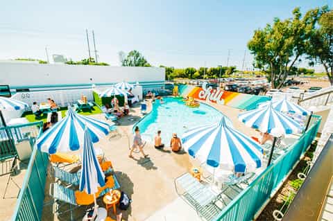 Overhead view of resort pool with blue and white striped umbrellas and water slide