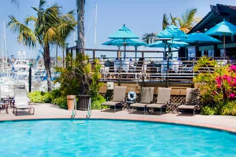 Waterfront pool with turquoise umbrellas and marina views
