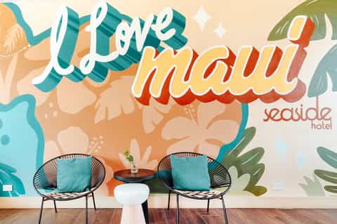 Colorful mural reading 'Life maui' with modern lounge seating and teal accent pillows