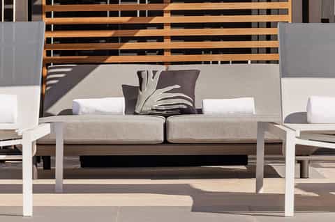 Modern outdoor lounge seating with comfortable cushioned sofa and wooden accent wall