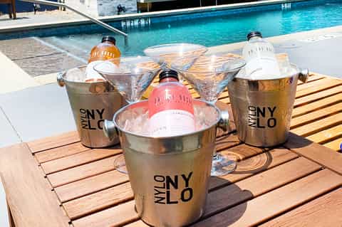 Cocktails with branded ice buckets poolside at modern beach resort