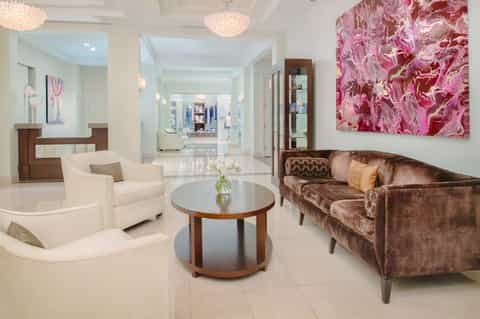 Elegant hotel lobby with cream seating, round table, and pink abstract artwork