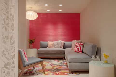 Colorful lounge seating area with bold red accent wall and mid-century modern furniture