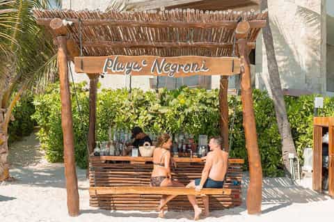 Beach bar with wooden pergola structure and tropical vegetation
