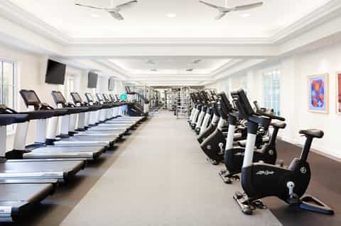 Spacious fitness center with rows of treadmills, stationary bikes, and exercise equipment