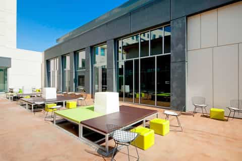 Contemporary outdoor courtyard with modern architecture, lounge seating, and glass sliding doors