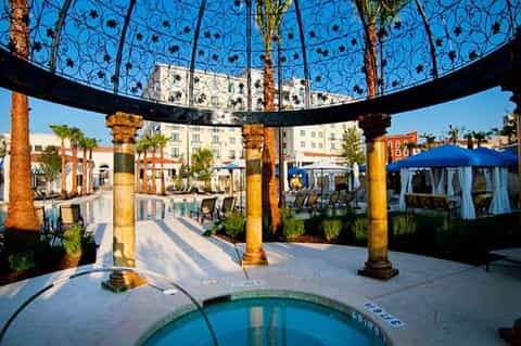 Ornate blue pergola with decorative ironwork and spa pool in courtyard setting
