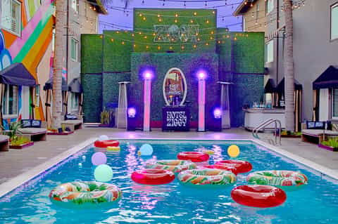 Hotel pool party with colorful decorations and illuminated backdrop