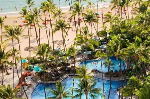 Aerial resort view with multiple pools, palm trees, and sandy beach access