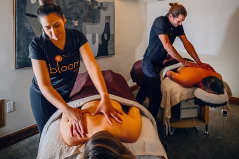 Massage therapy session at spa with therapists working on clients