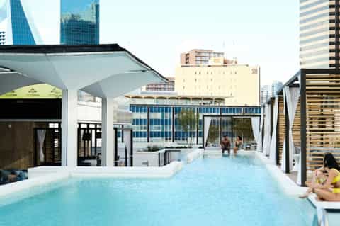 Modern rooftop pool with city skyline views and cabanas
