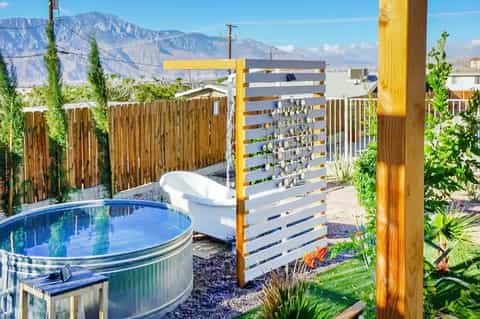 Backyard hot tub with wooden privacy fence and mountain views in daylight