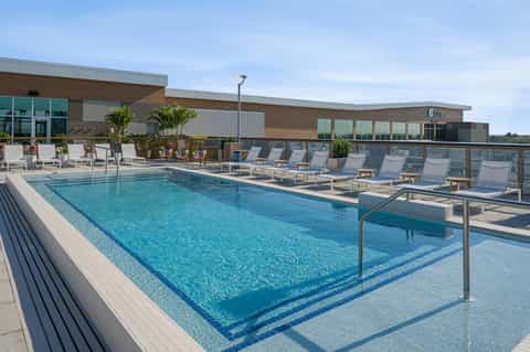 Contemporary hotel pool with lane dividers and lounge chairs on wooden deck