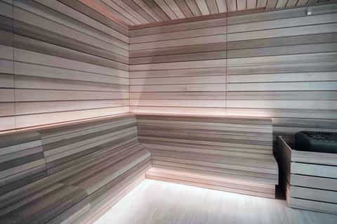 Modern sauna interior with light wood paneling and built-in benches, minimalist design