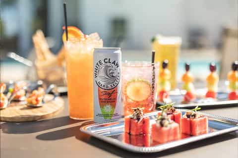 Poolside cocktails and appetizers featuring hard seltzer and colorful mocktails