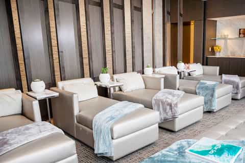 Luxury spa relaxation area with cream-colored lounge chairs and soft blankets in a modern wellness center