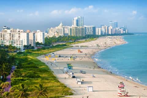 Aerial view of Miami Beach coastline with sandy shores, buildings, and turquoise ocean