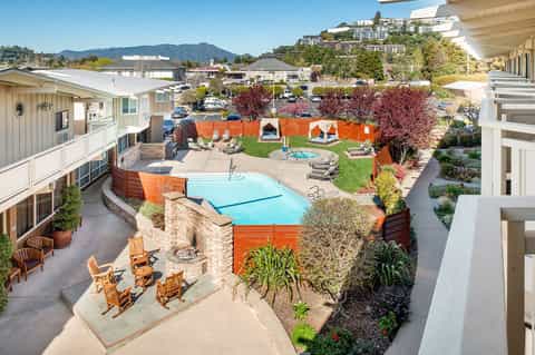 Mid-century modern resort pool with light blue water, orange accents, and mountain views
