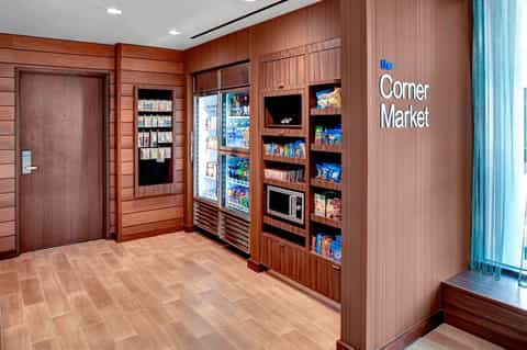 Hotel corner market convenience store with wooden interior, vending machines, and shelving