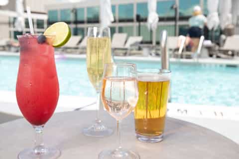 Colorful poolside cocktails and beverages on table with pool in background