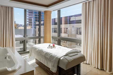Luxury spa treatment room with city views and modern furnishings