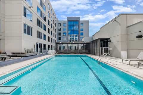Indoor lap pool with lane dividers, modern hotel building, and contemporary design