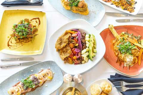 Gourmet seafood and vegetable dishes served on colorful ceramic plates